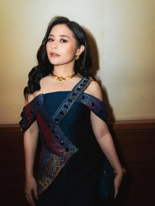 Ia mengenakan gaun bernuansa biru navy metalik dengan sedikit gold yang bikin Prilly terlihat glamor [@prillylatuconsina96]