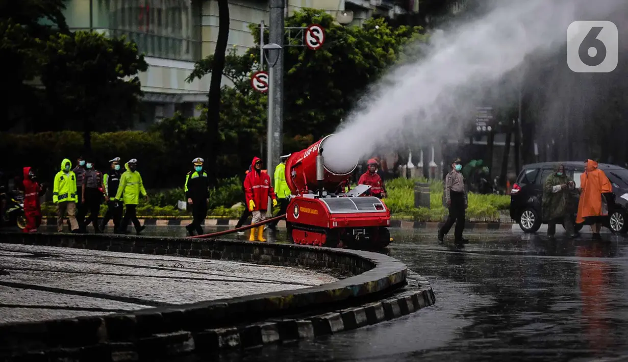 Petugas pemadam kebakaran menyemprotkan cairan disinfektan menggunakan robot LUF 60 di kawasan Bundaran HI, Jakarta, Minggu (22/3/2020). Penyemprotan untuk mencegah penyebaran virus corona COVID-19 ini dilakukan di lima wilayah Ibu Kota. (Liputan6.com/Faizal Fanani)