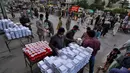Relawan membagikan makanan dan minuman manis tradisional untuk orang-orang berbuka puasa, di Rawalpindi, Pakistan, Minggu, (3/5/2020). Umat Muslim di seluruh dunia sedang melaksanakan Ramadan untuk menahan diri dari makan, minum sejak subuh sampai senja. (AP/Anjum Naveed)