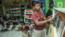 Anak-anak memilih buku di Pojok Baca Kampung Literasi RW 09, Kampung Pondok Jati, Palmeriam, Jakarta Timur, Senin (10/10/2022). Pojok Baca Kampung Literasi dibangun untuk menjadi fasilitas baru bagi anak-anak hingga orang dewasa yang berada di kawasan permukiman padat penduduk tersebut dalam memperkaya literasi dan meningkatkan minat membaca sejak dini. (merdeka.com/Iqbal S. Nugroho)