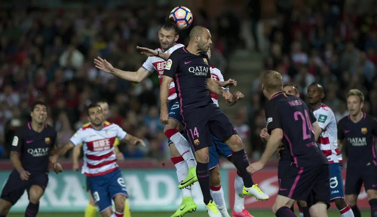 Bek Granada, Gaston Silva, duel udara dengan bek Barcelona, Javier Mascherano. Meskipun bermain di kandang Granada, Barcelona mampu menguasai pertandingan dengan 64 persen pengusaan bola sementara Granada hanya 36 persen. (AFP/Jorge Guerrero)