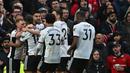 Selebrasi pemain Fulham setelah Aleksandar Mitrovic (tengah) menjebol gawang MU pada menit ke-50 dalam babak perempat final Piala FA 2022/2023 yang berlangsung di Old Trafford, Minggu (19/3/2023) malam WIB. (AFP/Paul Ellis)
