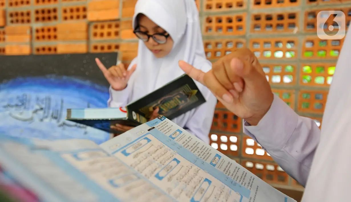Santriwati penyandang tuna rungu menghafal Al-Qur'an di Pesantren Tahfiz Difabel di Jalan Manunggal Jaya, Lebak Bulus, Jakarta Selatan, Senin (24/10/2022). Pondok Pesantren yang merupakan salah satu program untuk disabilitas dan diinisiasi oleh Baznas (Bazis) Provinsi DKI Jakarta diperuntukkan untuk tuna rungu secara gratis dan baru berjalan 3 bulan saat ini menampung 9 santriwati. (merdeka.com/Arie Basuki)