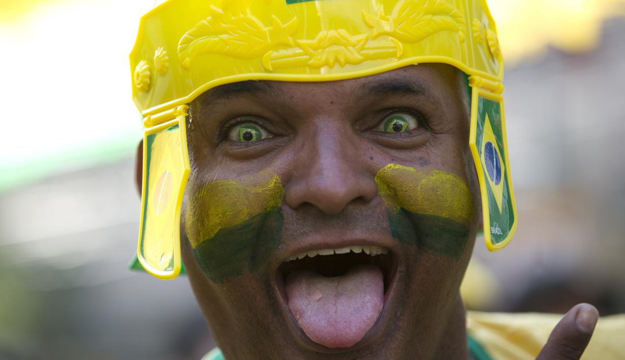 Fans dengan kontak lensa berbentuk bendera Brasil merayakan gol timnya atas Kosta Rika pada laga grup E Piala Dunia 2018 di Rio de Janeiro, Brasil, (22/6/2018). Brasil menang 2-0. (AP/Silvia Izquierdo)