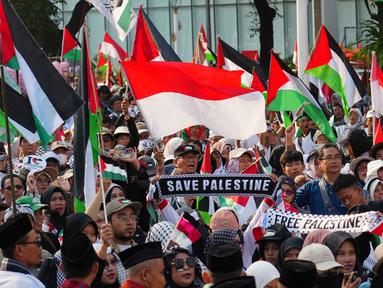 Para demonstran mengibarkan bendera Indonesia dan Palestina selama aksi unjuk rasa solidaritas untuk warga Palestina di Gaza, di Jakarta, Minggu 12 Oktober 2025. (AP Photo/Tatan Syuflana)