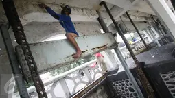Pekerja mengamplas pintu air Istiqlal, Jakarta Pusat, sebelum melakukan pengecatan, Senin (14/11). Pengecatan dilakukan untuk menjaga pintu air yang merupakan salah satu cagar budaya tersebut agar tetap bersih dan terawat. (Liputan6.com/Immanuel Antonius)