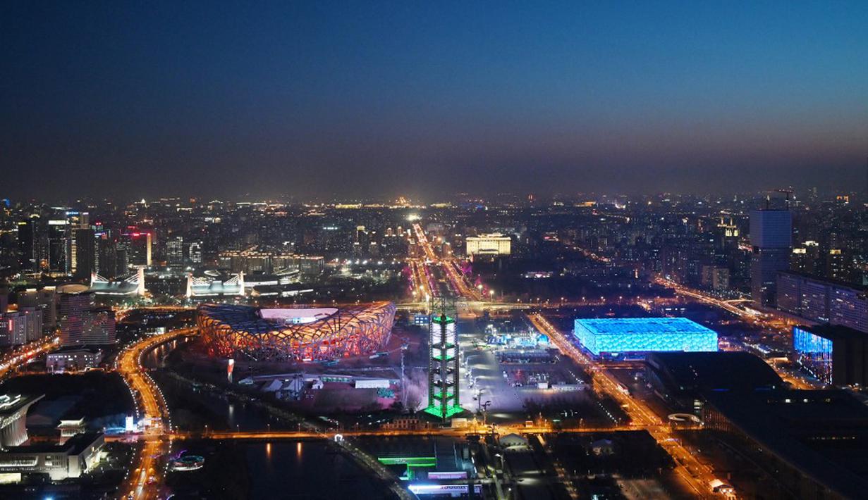 National Aquatics Center yang dikenal sebagai Ice Cube (kanan) venue untuk curling pada Olimpiade Musim Dingin 2022 dan National Stadium yang dikenal sebagai Bird's Nest (kiri) terlihat di Beijing, 3 Januari 2022. Olimpiade Musim Dingin 2022 akan dibuka pada 4 Februari mendatang. (GREG BAKER/AFP)
