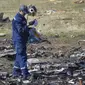 Seorang petugas melakukan penyelidikan di lokasi jatuhnya pesawat Malaysia Airlines MH17 di Desa Hrabove, daerah Donetsk, Ukraina timur. (VOA Indonesia)