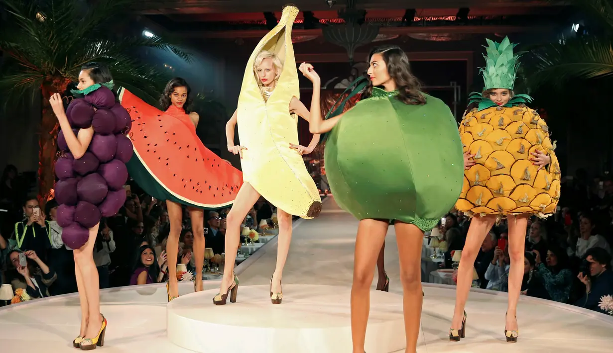 Para model membawakan busana karya Charlotte Olympia dalam London Fashion Week Spring/Summer 2017 di London, Inggris, (18/9). Model memperagakan busana unik dengan kostum berbagai buah. (REUTERS/Neil Hall)