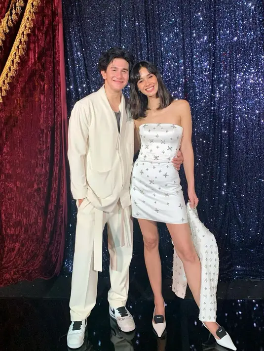 Dalam foto ini, keduanya tampil bak pasangan yang akan pergi ke prom night. Vino tampil tampan dengan mengenakan setelan atasan dan bawahan berwarna putih gading, lengkap dengan sneakers berwarna putih, sedangkan Marsha tampil cantik dengan off-the-shoulder mini dress dengan payet-payet berkilauan, dan kitten heels yang juga berwarna putih. Foto: Instagram.