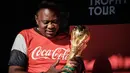 Presiden Kenya Uhuru Kenyatta memegang trofi Piala Dunia FIFA saat Tur Dunia di Gedung Negara, Nairobi (26/2). Setelah Kenya, trofi Piala Dunia ini akan diberangkatkan ke Mozambik. (AFP Photo/Yasuyoshi Chiba)