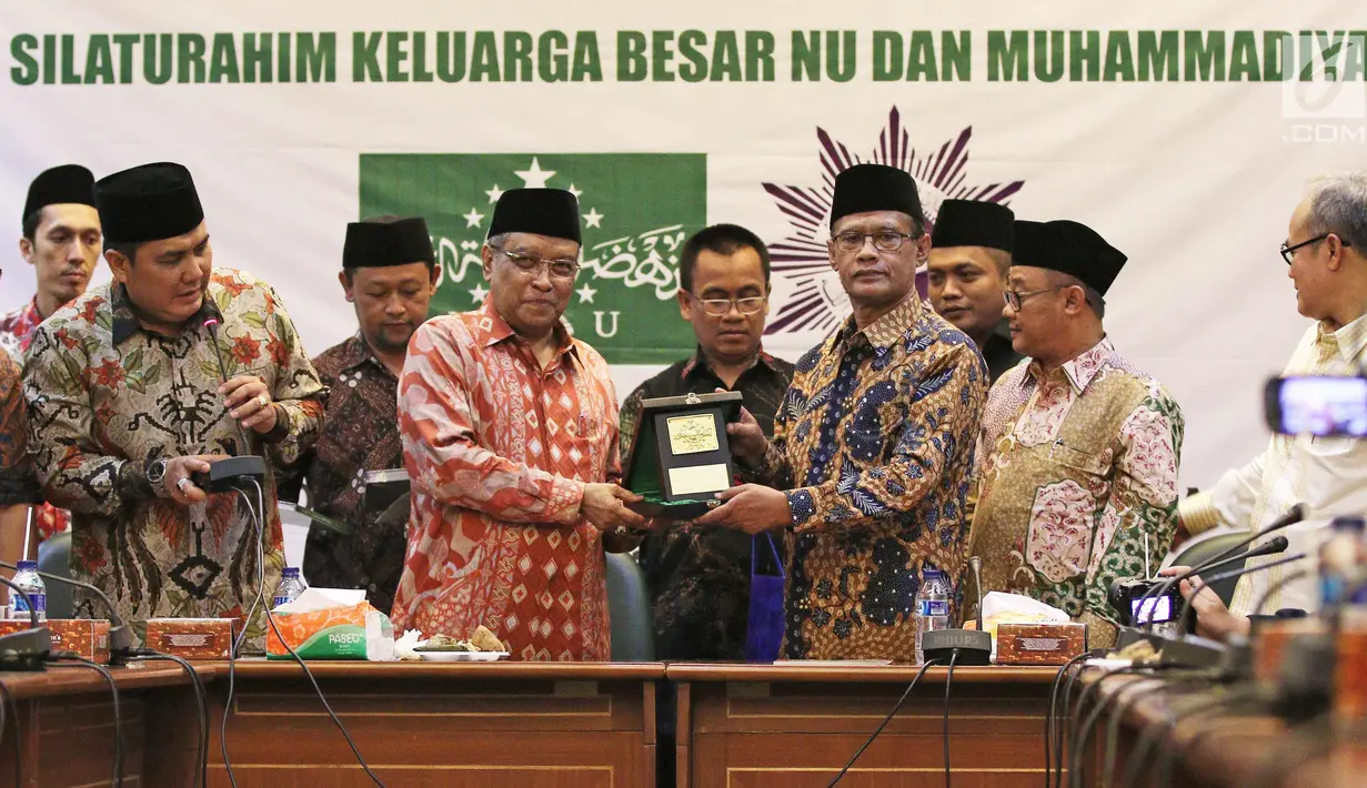Ketua Umum PBNU KH. Said Aqil Siradj memberikan cindermata ke Ketua Umum PP Muhammadiyah H. Haedar Nashir saat silaturahim keluarga besar NU dan Muhammadiyah di kantor PBNU, Jakarta, Jumat (23/3). (Liputan6.com/Herman Zakharia)