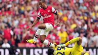 Striker Arsenal Theo Walcott (kiri) melompat menghindari benturan dengan kiper Tottenham Hotspur Hugo Lloris (kanan) pada pertandingan sepak bola Liga Utama Inggris antara Arsenal dan Tottenham Hotspur di Stadion Emirates di London (01/09/2013). (AFP/Glyn
