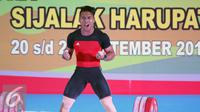 Lifter Jawa Barat, Deni melambaikan tangan usai mengangkat beban 183kg clean and jerk kelas 69kg PON XIX Jabar di Gymnasium Si Jalak Harupat, Kab Bandung, Rabu (21/9). Deni meraih emas dengan total angkatan 328kg. (Liputan6.com/Helmi Fithriansyah)