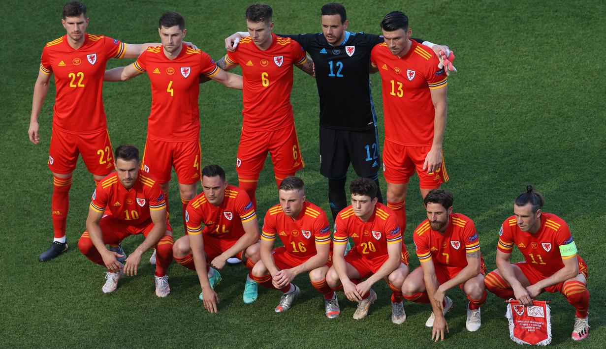 Formasi "berantakan" Timnas Wales mengundang perhatian kala mereka berjumpa dengan Timnas Swiss di laga perdana Grup A Euro 2020. Berbeda dengan pose tim pada umumnya, mereka dengan sengaja memilih bergaya asimetris dan terkesan berantakan. (Foto: AFP/Pool/Naomi Baker)