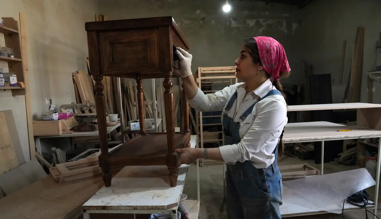 Tukang kayu Iran Sahar Biglari melukis produk saat bekerja di bengkelnya di Teheran, Iran, 12 Maret 2023. Semakin banyak perempuan Iran berjuang untuk mengatasi hambatan gender. (AP Photo/Vahid Salemi)