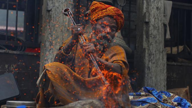 Seorang sadhu (lelaki suci Hindu) membuat api untuk menghangatkan dirinya selama festival Shivaratri di lokasi kuil Pashupatinath di Kathmandu, Nepal (20/2/2020). Festival ini  didedikasikan untuk 'Malam Besar Siwa', dewa Hindu yang berdoa dan berpuasa bagi orang percaya. (AP/Niranjan Shrestha)