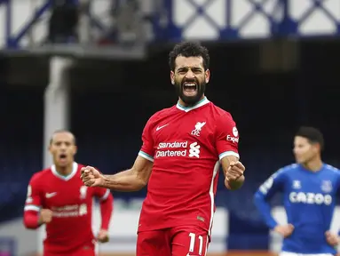 Pemain Liverpool Mohamed Salah (11) melakukan selebrasi usai mencetak gol ke gawang Everton pada pertandingan Liga Premier Inggris di Stadion Goodison Park, Liverpool, Inggris, Sabtu (17/10/2020). Pertandingan berakhir dengan skor 2-2. (Cath Ivill/Pool via AP)