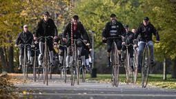 Para penggemar mengenakan pakaian bersejarah mengendarai sepeda yang mereka sebut penny-farthing, atau yang juga dikenal sebagai high wheel, dalam kompetisi tradisional 'One Mile Race' di Taman Letna, Praha, Republik Ceko, pada 1 November 2025. Mereka ikut serta dalam kompetisi tradisional 'One Mile Race'. (Michal Cizek/AFP)