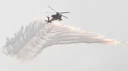 Helikopter tempur AH-1W Super Cobra melepaskan flare selama latihan tahunan Han Kuang di sebuah pangkalan udara di Taichung, Kamis (7/6). Latihan militer tahunan terbesar ini digelar di tengah kian agresifnya China terhadap Taiwan. (AP/Chiang Ying-ying)