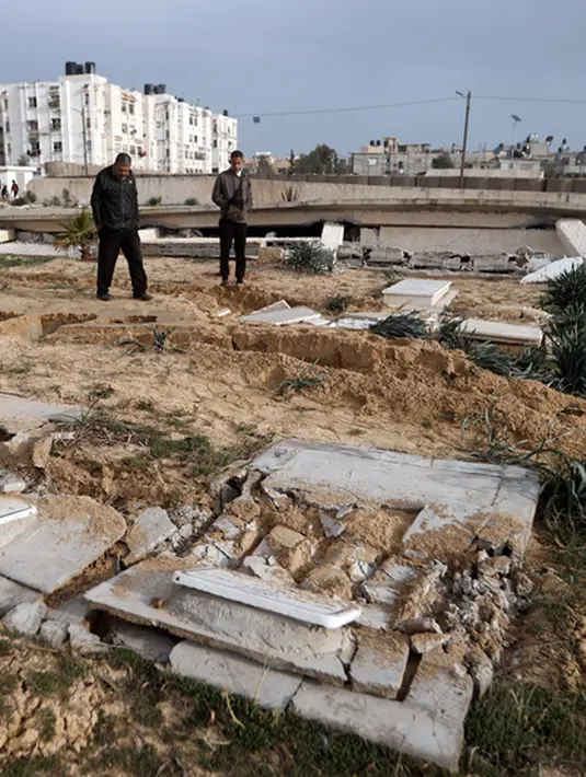 <p>Warga Palestina memeriksa pemakaman yang rusak menyusul serangan tank Israel di pemakaman di kamp pengungsi Khan Younis, Jalur Gaza selatan, Rabu (17/1/2024). (AP Photo/Mohammed Dahman)</p>