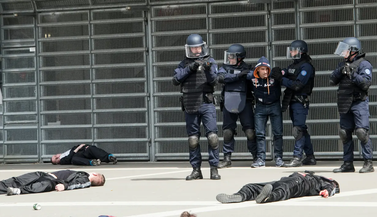Polisi menahan salah satu teroris saat latihan serangan teroris di Stadion Pierre Mauroy di Lille, Prancis (21/4). Jelang Euro 2016, Polisi Prancis mengelar latihan mengantisipasi terjadinya serangan teror yang tidak diinginkan. (AFP PHOTO/DENIS Charlet)