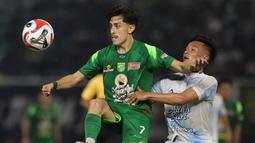Pemain Persebaya Surabaya, Rivera (kiri) mencoba mengamankan bola dari pemain PSIM Yogyakarta pada pertandingan pembuka BRI Super League 2025/2026 di Stadion Gelora Bung Tomo, Jumat (08/08/2025) malam WIB. (Bola.com/Abdul Aziz)