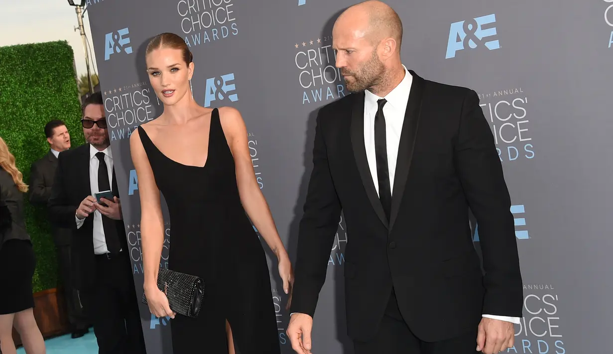 Rosie Huntington Whiteley bersama tunanganya Jason Statham saat tiba pada ajang Critics' Choice Awards ke-21 di Santa Monica, California, Minggu (17/1). Mereka dikabarkan bertunangan waktu berlibur bersama ke Thailand. (Jason Merritt/Getty Images/AFP)