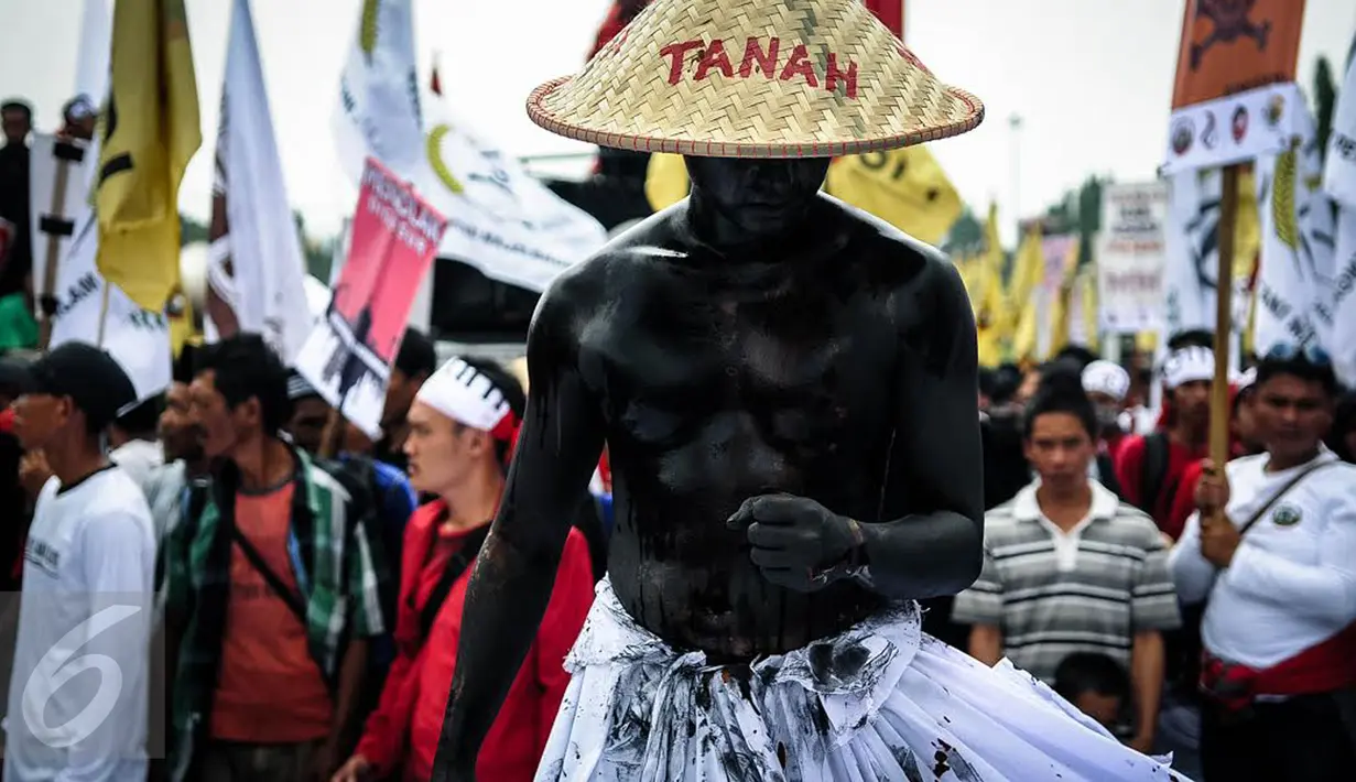 Seorang massa petani dari berbagai provinsi melakukan aksi teatrikal saat menggelar demonstrasi di kawasan Medan Merdeka, Jakarta, Selasa (27/9). Aksi menyuarakan aspirasi petani itu digelar dalam rangka Hari Tani Nasional. (Liputan6.com/Faizal Fanani)