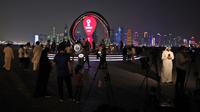 Pengunjung berkumpul dekat jam hitung mundur yang menandai 30 hari dimulainya Piala Dunia Qatar 2022 di ibu kota Qatar, Doha, Kamis (20/10/2022). Penyelenggara Piala Dunia Qatar mengatakan bahwa 30.000 kamar telah tersedia untuk pengunjung Piala Dunia. (Photo by Jewel SAMAD / AFP)