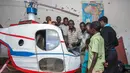 Felix Kambwiri dan sejumlah teman berpose dengan helikopter buatannya di garasi rumahnya di Desa Gobede, Malawi, 19 Februari 2016. Helikopter yang dikerjakan sejak empat bulan lalu itu dibuat dari rongsokan besi tua dan fiberglass. (Amos Gumulira/AFP)