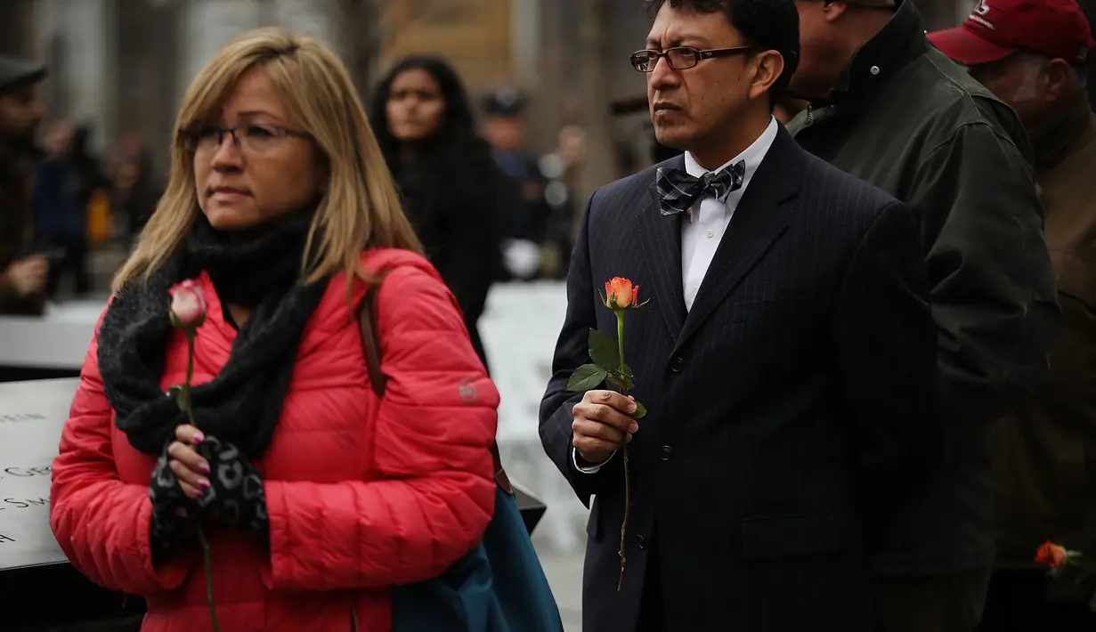Orang-orang menaruh bunga mawar dalam peringatan 25 tahun serangan bom truk di WTC, New York City, Amerika Serikat, Senin (26/2). (Spencer Platt/Getty Images/AFP)