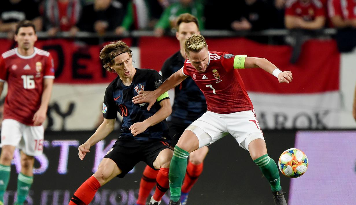 Pemain Hungaria, Balasz Dzsudzsak melewati Luka Modric pada laga kedua babak kualifikasi Piala Eropa 2020 Grup E yang berlangsung di Stadion Groupama Arena, Budapest, Senin (25/3). Kroasia kalah 1-2 kontra Hungaria. (AFP/Attila Kisbenedek)