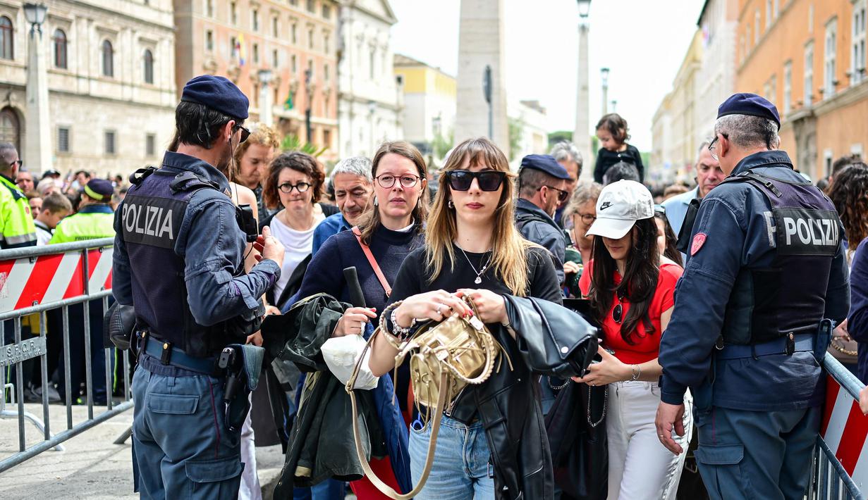 Ribuan orang rela antre berjam-jam di bawah terik matahari musim semi di Lapangan Santo Petrus, Vatikan, demi memberikan penghormatan terakhir kepada Paus Fransiskus. (Piero CRUCIATTI/AFP)