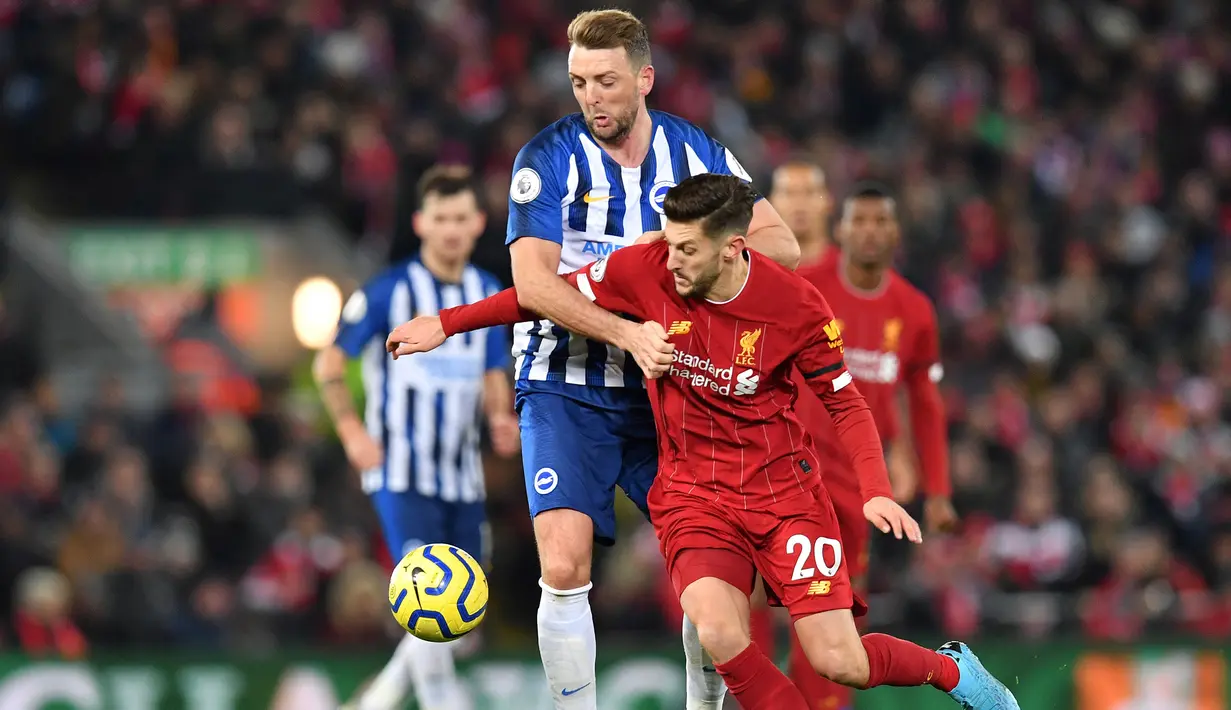 Gelandang Liverpool, Adam Lallana, berebut bola dengan gelandang Brighton, Dale Stephens, pada laga Premier League di Stadion Anfield, Liverpool, Sabtu (1/12). Liverpool menang 2-1 atas Brighton. (AFP/Paul Ellis)