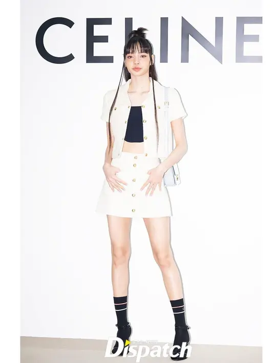 Biasa tampil boyish, kali ini Lisa terlihat feminin cropped chelsea jacket, crop top, dan trapeze mini skirt serba putih. [Foto:IG/koreadispatch].