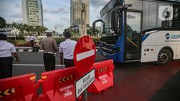 Petugas gabungan mengatur lalu lintas saat uji coba rekayasa lalu lintas di kawasan Bundaran HI, Jakarta Pusat, Senin sore (4/7/2022).  Rekayasa lalu lintas di Bundaran HI juga untuk mengurai kepadatan akibat persilangan (crossing). (Liputan6.com/Faizal Fanani)