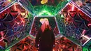 Seorang wanita Martine Basson menikmati seni instalasi lampu karya Amberlights saat festival Canary Wharf Winter Lights di London (16/1). Seni instalasi cahaya karya seniman Amberlights ini berjudul Dazzling Dodecahedron. (Matt Alexander / PA via AP)