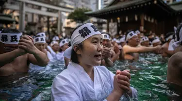 Penganut Shinto mandi dengan air dingin di Kuil Teppozu Inari, Tokyo, Jepang, 8 Januari 2023. Ritual Tahun Baru ini dilakukan untuk memurnikan jiwa dan raga. (Philip FONG/AFP)