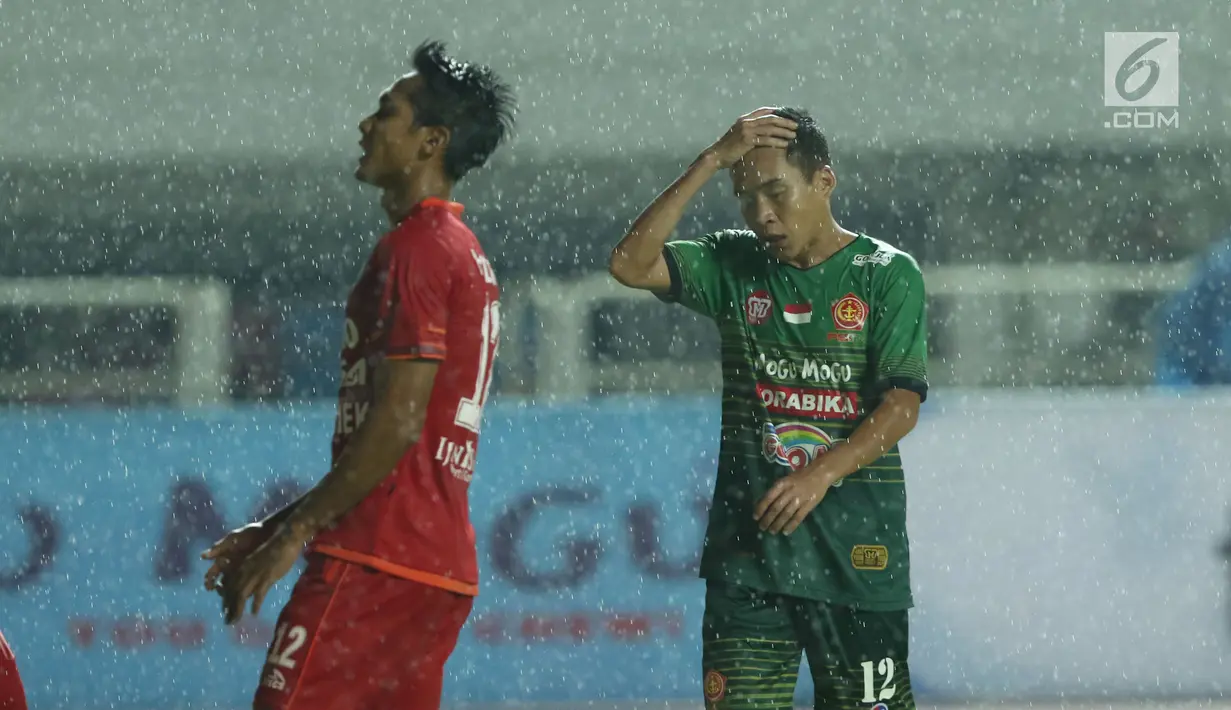 Pemain tengah PS TNI, Erwin Ramdani (kanan) memegang kepala saat gagal mencetak gol ke gawang Arema FC dilanjutan Liga 1 Indonesia di Stadion Pakansari, Bogor, Senin (3/7). Laga kedua tim berakhir imbang 0-0. (Liputan6.com/Helmi Fithriansyah)