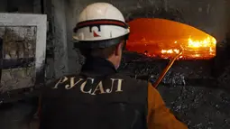 Salah satu pekerja mengawasi langsung proses pencampuran material alumunium di Rusal Krasnoyarsk, Siberia, (8/7/2014). (REUTERS/Ilya Naymushin)