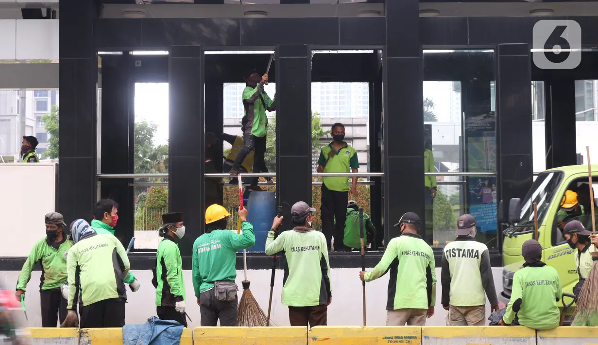 Sejumlah petugas membersihkan puing Halte Bus TransJakarta Tosari yang dirusak saat kericuhan unjuk rasa menolak pengesahan UU Cipta Kerja di Jakarta, Jumat (9/10/2020). Sejumlah fasilitas umum rusak dalam kericuhan yang terjadi Kamis (8/10). (Liputan6.com/Angga Yuniar)