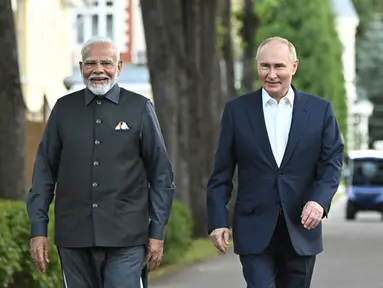 Perdana Menteri India Narendra Modi (kiri) dan Presiden Rusia Vladimir Putin berjalan saat pertemuan informal di kediaman Novo-Ogaryovo, di luar Moskow, Rusia, Senin (8/7/2024). (Sergei Bobylev, Sputnik, Kremlin Pool Photo via AP)