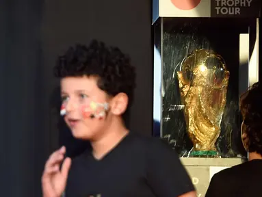 Seorang anak melihat trofi Piala Dunia FIFA  saat tur Dunia di Ibu Kota Kairo, Mesir (15/3).  Piala Dunia 2018 akan berlangsung pada bulan Juni di Rusia. (AFP Photo/Khaled Desouki)