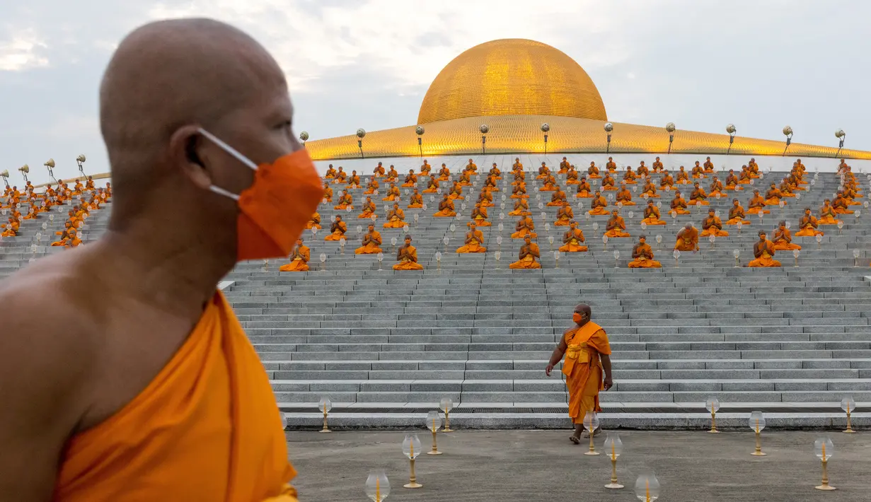 Biksu Buddha menghadiri perayaan Makha Bucha di kuil Wat Dhammakaya di provinsi Pathum Thani, utara Bangkok (16/2/2022). Makha Bucha merupakan salah satu hari raya terpenting bagi para penganut agama Buddha. (AFP/Jack Taylor)