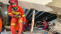 Tim penyelamat mencari korban yang terjebak di bawah reruntuhan bangunan di sebuah pondok pesantren di Sidoarjo, Jawa Timur, Rabu 1 Oktober 2025. (AP Photo/Trisnadi)