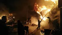 Petugas pemadam kebakaran berjuang melawan kobaran api setelah serangan udara Israel di Pelabuhan Latakia, Suriah, 28 Desember 2021. Sejak pecahnya perang saudara Suriah pada tahun 2011, Israel secara rutin melakukan serangan udara terhadap tetangganya yang dilanda perselisihan itu. (SANA/AFP)