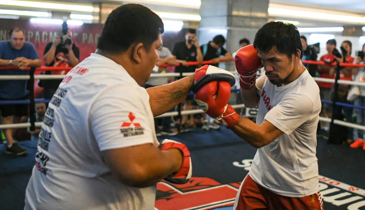 Petinju asal Filipina, Manny Pacquiao (kanan) berlatih selama sesi pelatihannya di sebuah gym di Kuala Lumpur, Malaysia (11/7). Manny Pacquiao dan Lucas Matthysse akan bertanding pada 15 Juli 2018. (AFP Photo/Mohd Rasfan)