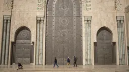 Umat Muslim berjalan setelah melaksanakan salat Jumat di luar masjid Hassan II, salah satu yang terbesar di Afrika, di Casablanca, Maroko (7/2/2020). Masjid ini disebut-sebut sebagai yang terbesar kedua di dunia setelah Masjidil Haram di Kota Mekkah. (AP Photo/Mosaab Elshamy)