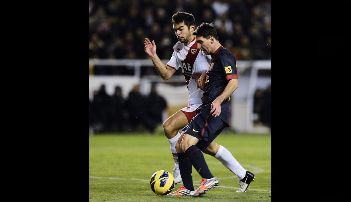 Pemain Rayo Vallecano, Jordi Amat (kiri), menjaga pergerakan dari pemain Barcelona, Lionel Messi,  dalam pertandingan lanjutan La Liga 2012/2013 yang berlangsung di stadion Vallecas, Sabtu (27/10/2012). (AFP/Pierre-Philippe Marcou)